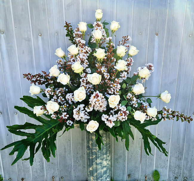 centro floral para funeral con rosas blancas
